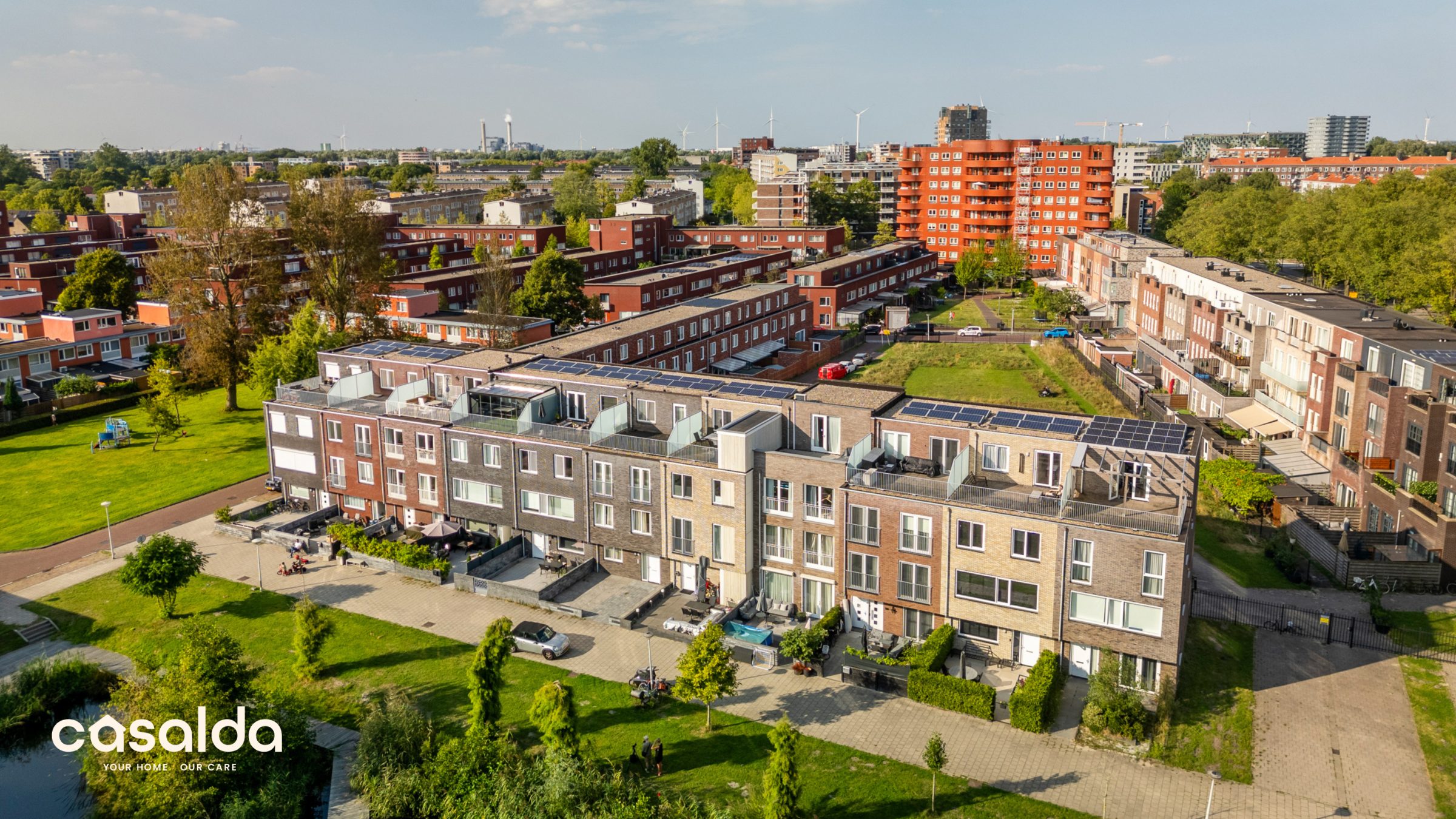 aerial view of a new-build neighborhood with solar panels, carrying the casalda logo