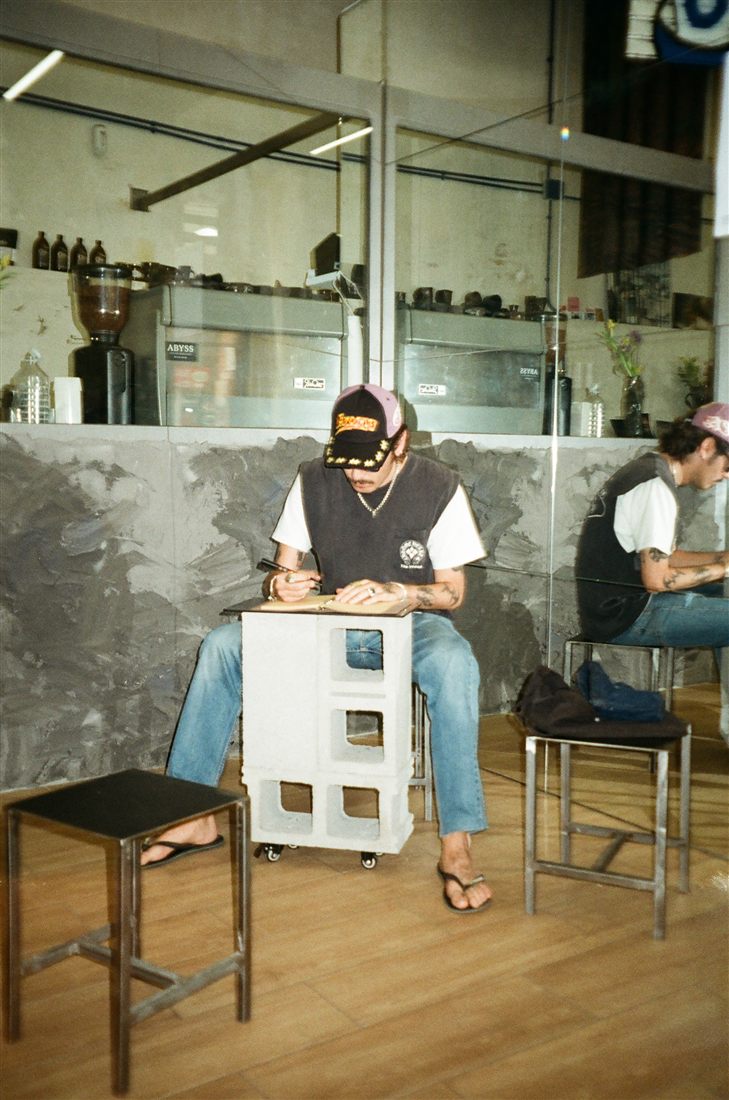 Sketching in a notebook in a concrete and glass coffee bar